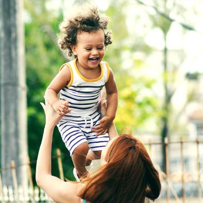 Woman tossing a toddler in the air